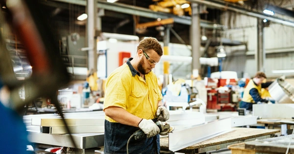 man doing metalwork in a factory