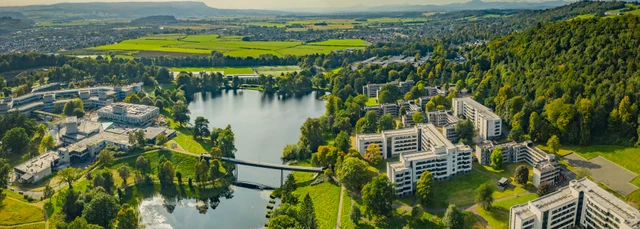 Aerial view of the campus with the loch and the bridge