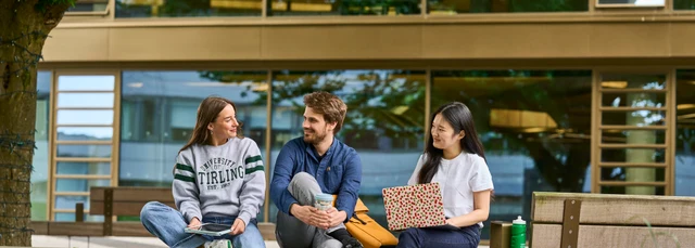 Three students sitting in Queens Court