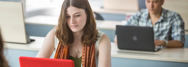 Student working on a red laptop