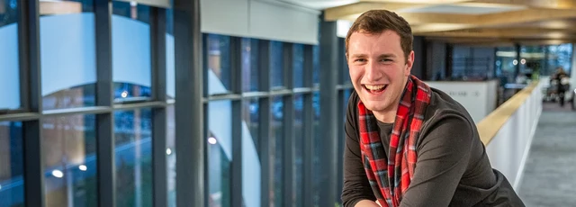 Student standing in the INTO building