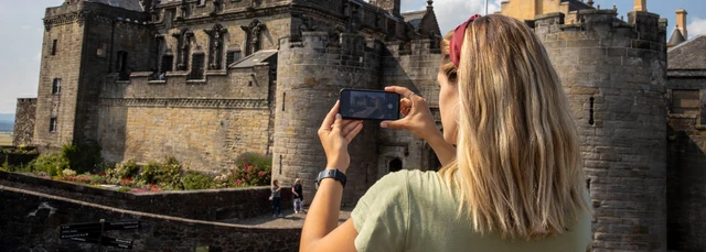 A student taking a picture of Stirling Castle on their phone