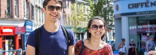 Two happy students shopping in Stirling city centre on a sunny day