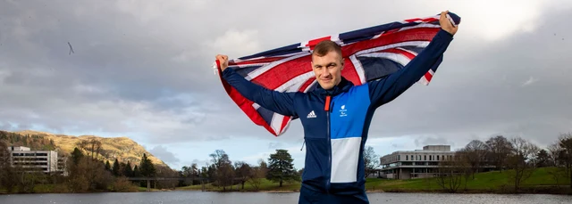 Scott Meenagh holding a flag above his head