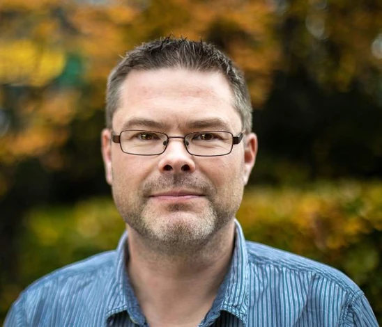 man with glasses and blue shirt